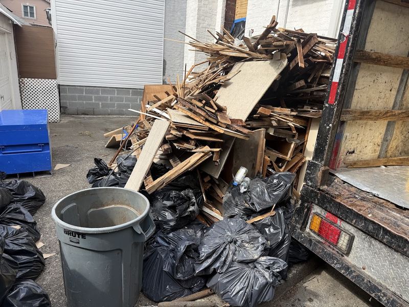Broken wood and demolition debris being loaded into the truck