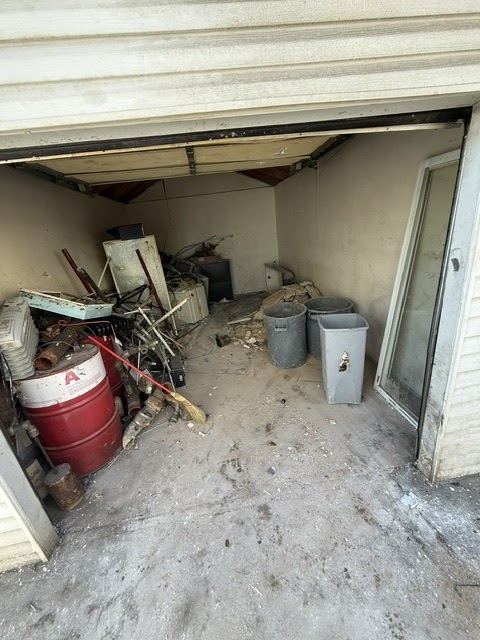 Open garage filled with old appliances and clutter before a garage clean out in Queens
