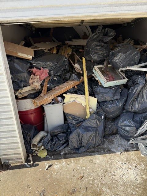 Storage shed packed with boxes, bags and old items before a clean out